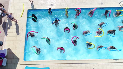 Gruppe-Von-Frauen,-Die-Wassergymnastik-In-Einem-Außenpool-Machen.-Drohnenansicht